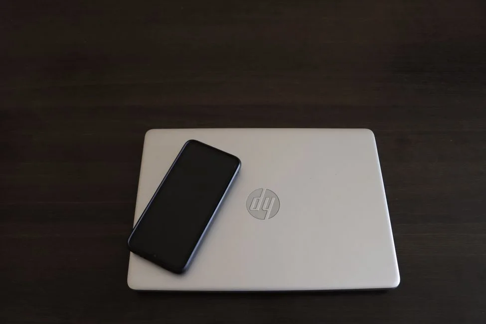 Laptop and smartphone used to compare CapCut Pro across devices