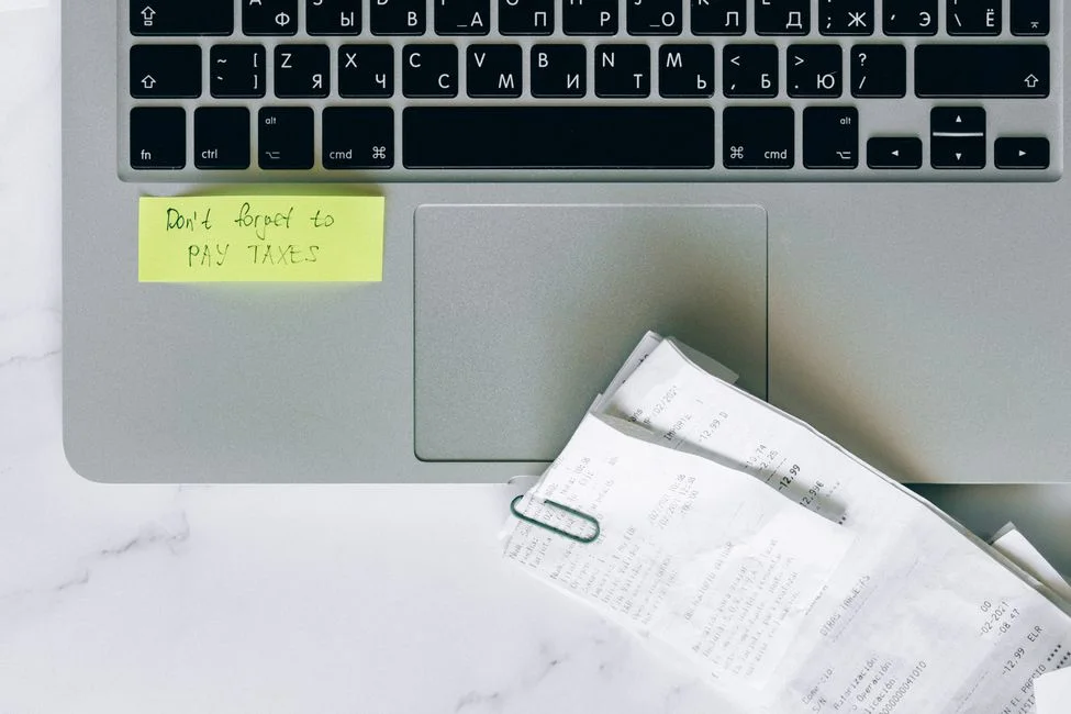 Receipts beside a laptop while checking a missing CapCut Pro subscription