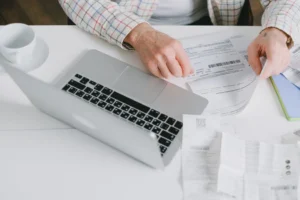 Person matching subscription documents to account details on a laptop