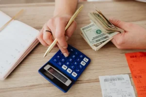 Person working with a notebook and calculator at a desk