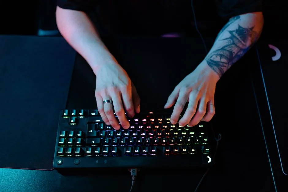 Person seated at a desk in a dim room.