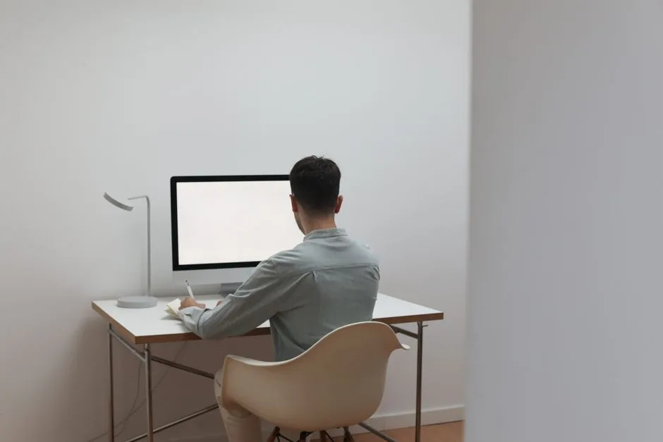Person comparing notes at a computer desk