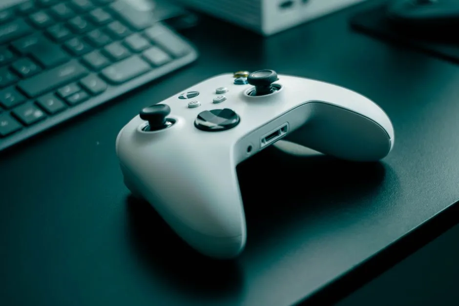 A person comparing notes at a desk with a keyboard and game controller.